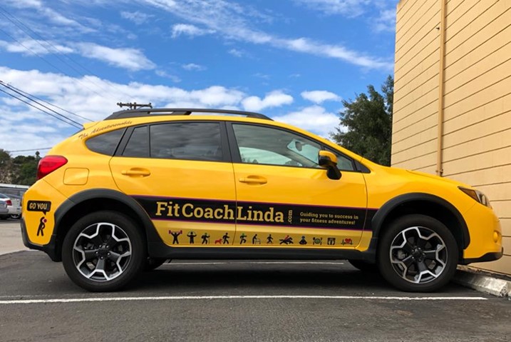 The Adventuremobile - a bright, sunrise-yellow Subaru Crosstrek, with bold Fit Coach Linda branding graphics