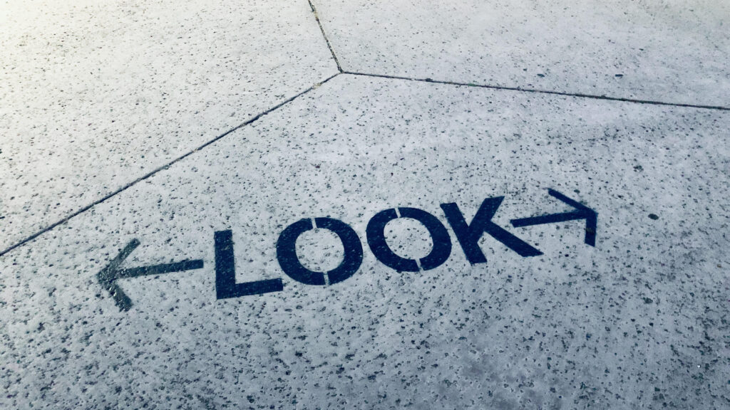 A photo of the word "LOOK" in all caps, stenciled onto a concrete floor.